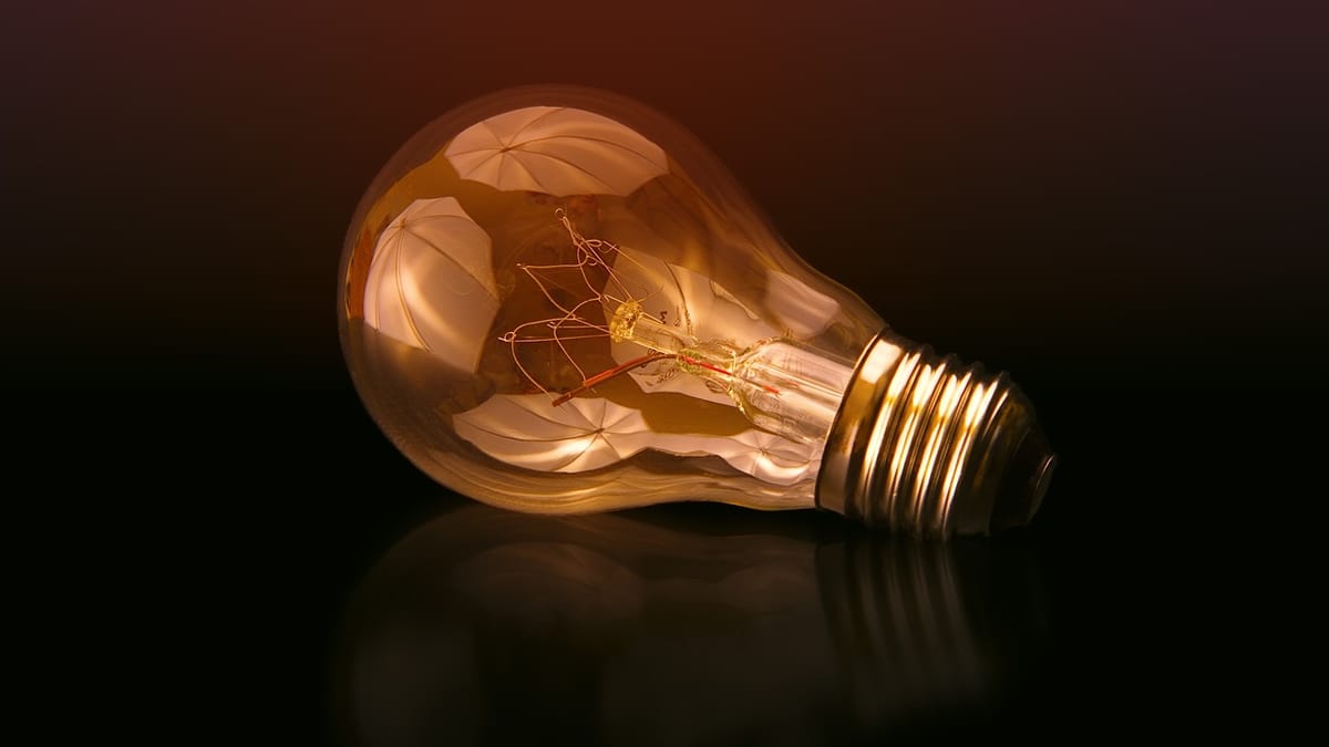 Ampoule à filament allumée, couchée sur une surface sombre